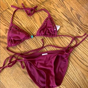 Maroon bathing suit with cut outs and a blue stone